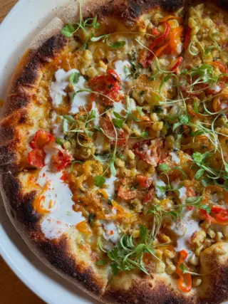 The street corn pizza is back! lykens valley cheese blend, cotija, wood grilled corn, pickled peppers, lime crema, chile oil, and cilantro make this an all time favorite and we are delighted to bring it back for the season! Stop in and enjoy one tonight!